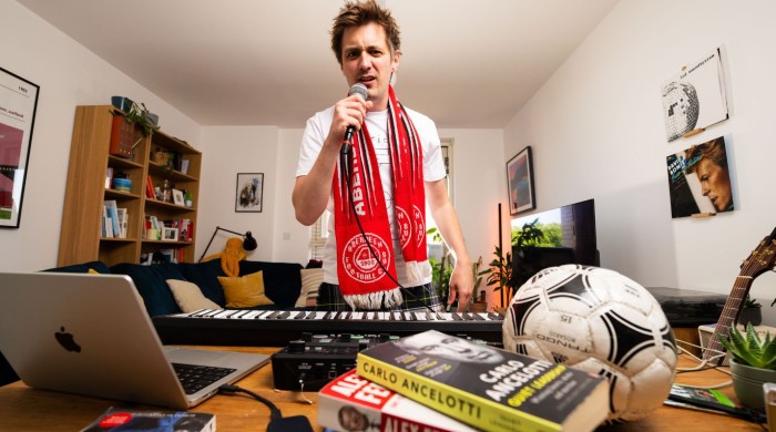 Man wearing an aberdeen FC scarf standing in a living room